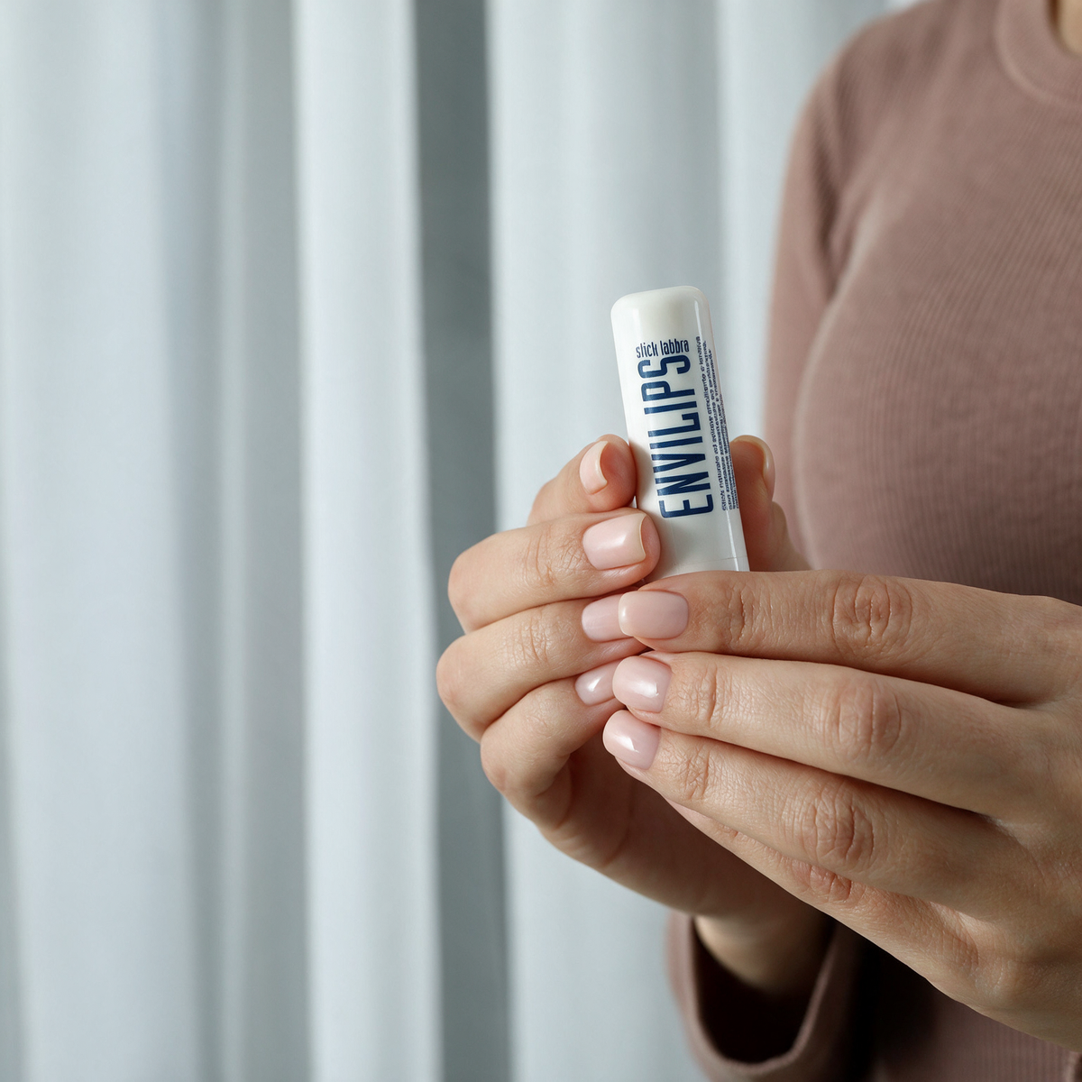 Mani che tengono lo stick labbra Envilips® 7,5 ml